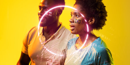 Circle neon over african american fans with flags painted on cheeks during soccer match. Digital composite, yellow background, england flag, brazil flag, sport, spectator, love.の写真素材