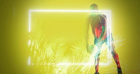 African american rugby player standing by illuminated plants and rectangle on yellow background....