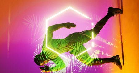 Side view of african american rugby player running by illuminated hexagon and plants, copy space....