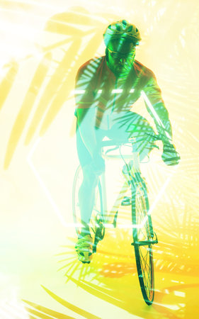 African american male cyclist riding bike with safety gear over illuminated yellow plants. Copy space, composite, sport, cycling, racing, nature, shape, competition and abstract concept.の写真素材