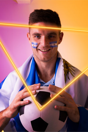 Portrait of caucasian male player with soccer ball and flag of argentina by illuminated triangle. Copy space, composite, sport, competition, soccer, closeup, patriotism and abstract concept.の写真素材