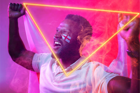 African american male fan with england flag and face paint screaming by illuminated triangle. Copy...