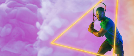 African american male tennis player holding racket by illuminated triangle over smoky background. Copy space, composite, sport, competition, shape, playing, match and abstract concept.の写真素材