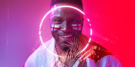 African american smiling male fan with england flag and face paint over illuminated circle and plant. Copy space, composite, sport, competition, soccer, support, nature, shape, patriotism, cheering.の写真素材