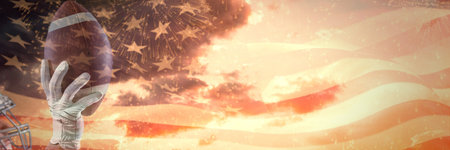 Composition of hand with rugby ball and flag of usa over clouds with copy space. Global science, celebration and sport concept digitally generated image.の写真素材