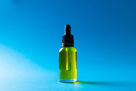 Image of glass bottle with pump and copy space on blue background. Plastic free beauty, health and beauty, sustainability concept.の写真素材