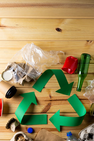 Close up of recycling symbol of paper green arrows and paper, glass trash with copy space. Global...