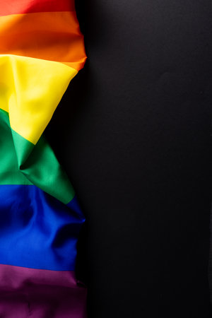 Rainbow coloured flag with copy space on black background. Pride month, equality, lgbt and human rights concept.の写真素材