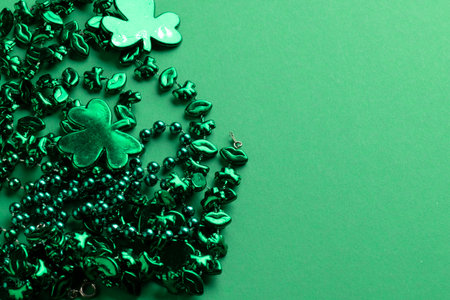 Image of green clover and jewellery and copy space on green background. St patrick&#39;s day, irish tradition and celebration concept.の写真素材