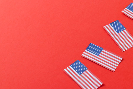 High angle view of four flags of united states of america with copy space on red background. American patriotism, independence day and tradition concept.の写真素材