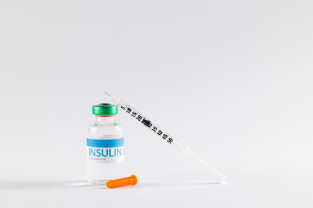 Insulin in vial and uncapped syringe on white background with copy space. Blood sugar, diabetes and health awareness.の写真素材