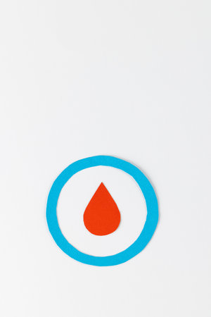 Blood drop in blue ring on white background with copy space. Blood sugar, diabetes and health awareness.の写真素材