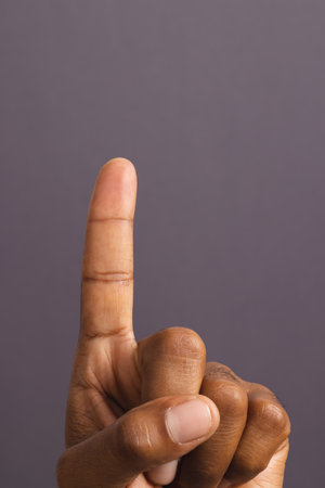 Hand of biracial man with outstretched forefinger, on grey background with copy space. Pin prick test, blood sugar, diabetes and health awareness.の写真素材