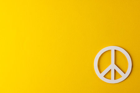 High angle view of white peace sign with copy space on yellow background. Peace and anti war movement concept.の写真素材