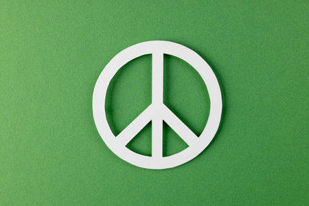 High angle view of white peace sign with copy space on green background. Peace and anti war movement concept.の写真素材