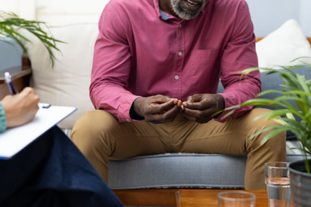 Midsection of african american male patient attending therapy with therapist. Mental health, therapy and counselling.の写真素材