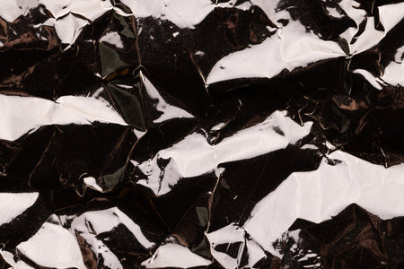 Close up of crumpled and shiny gold foil with copy space. Colour, texture and material.