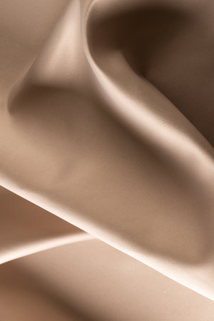 Close up of plain beige satin fabric with folds, copy space. Colour, texture and material.の写真素材