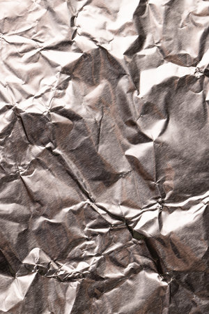 Close up of crumpled and shiny gold foil with copy space. Colour, texture and material.