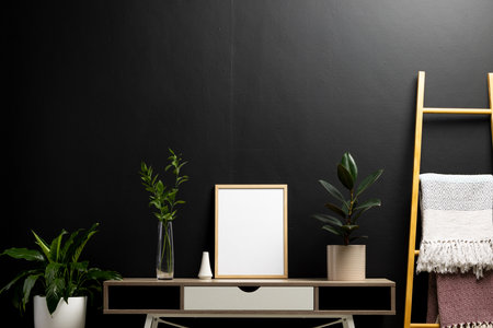 Wood empty frame with copy space and plants in pots on desk against black wall. Mock up frame template, interior design and decoration.の写真素材
