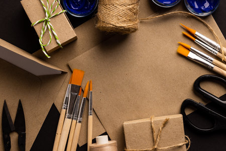 Image of close up of scissors, paint brushes and threads and copy space on cream background. Painting, arts and crafts concept.の写真素材