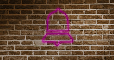 Image of pink neon bell icon on brick background. Social media and digital interface concept digitally generated image.の写真素材
