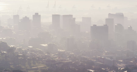 General view of misty modern cityscape with skyscrapers and building site. Global business and city.