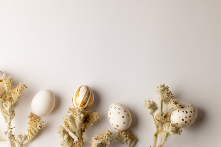 Image of multi coloured easter eggs and plants with copy space on white background. Easter, religion, tradition and celebration concept.の写真素材