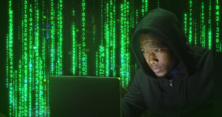Composition of data processing over african american male hacker using laptop in server room....
