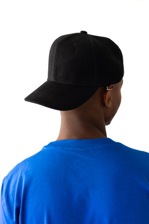 African american man wearing blue t-shirt and black cap with copy space on white background....