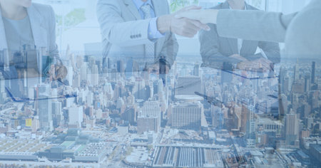 Composition of businessman hand shake in office over cityscape. business, finances, success and communication concept digitally generated image.の写真素材
