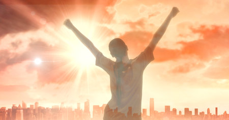 Composition of sports woman with arms in air celebrating over cityscape. sport, fitness and active lifestyle concept digitally generated image.の写真素材