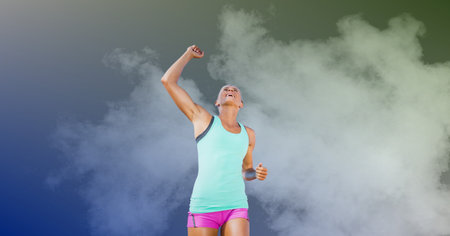 Composition of smiling fit caucasian female athlete celebrating win with copy space. sport, fitness and active lifestyle concept digitally generated image.の写真素材