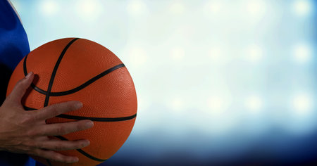 Composition of midsection of female basketball player with ball, spotlights and copy space. sport and competition concept digitally generated image.の写真素材