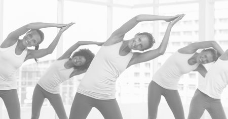 Composition of group of happy women exercising in fitness class in black and white. sport, fitness and active lifestyle concept digitally generated image.の写真素材