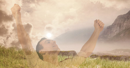 Composition of sports man with arms in air celebrating over mountains landscape. sport, fitness and active lifestyle concept digitally generated image.の写真素材