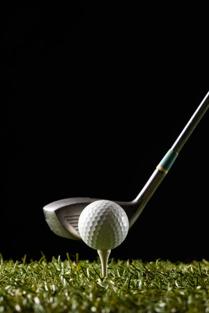 White golf ball on golf tee and golf club on grass with copy space. Golf, sports and competition concept.の写真素材