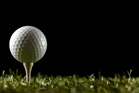 White golf ball on golf tee on grass with copy space. Golf, sports and competition concept.の写真素材