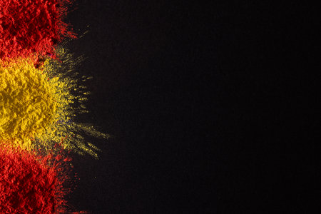 Close up of red and yellow coloured powder and copy space on black background. Holi festival, colour, hindu tradition and celebration concept.の写真素材