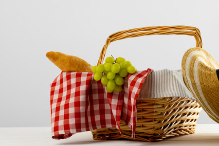 Picnic basket with red and white vichy fabric and food over white backgrounds. Picnic, eating outside, relaxing in nature concept.の写真素材
