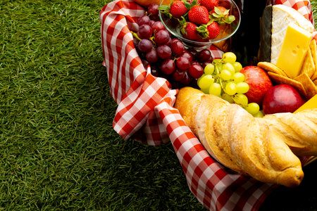 Picnic basket with diverse food lying on grass. Picnic, food, eating outside, relaxing in nature concept.の写真素材