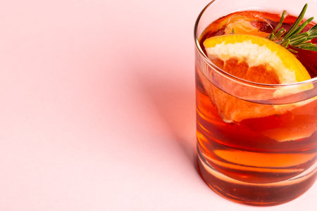 Glass with drink and fruits over pale pink background. Drinks, cocktails, beverages and party concept.の写真素材