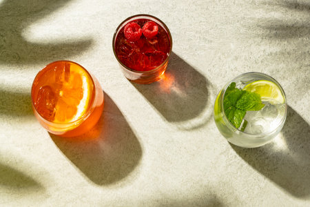 Glasses with diverse cocktails with drinks over beige background with shadows. Drinks, cocktails, beverages and party concept.の写真素材
