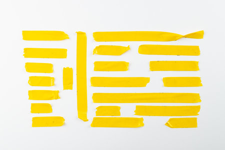 Ripped up pieces of yellow tape with copy space on white background. Abstract paper texture background and communication concept.の写真素材