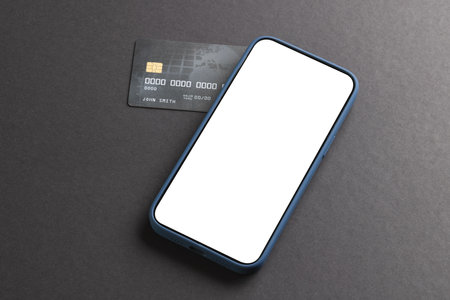 Smartphone with blank screen and credit card on black background. Cyber shopping, retail, technology, electronic device and communication concept.の写真素材