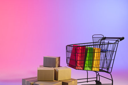Shopping trolley with bags, boxes and copy space over neon purple background. Cyber monday, black friday, online shopping, shipping and global connections concept.の写真素材