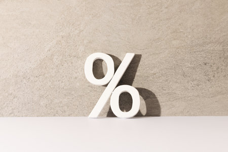White percent sign with copy space against grey stone wall background. Black friday, cyber monday, shopping, cyber shopping, sales, retail and shipping concept.の写真素材