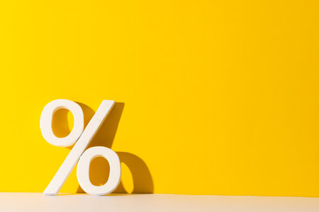 White percent sign with copy space against yellow background. Black friday, cyber monday, shopping,...