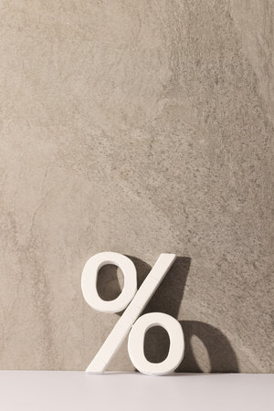 White percent sign with copy space against grey stone wall background. Black friday, cyber monday, shopping, cyber shopping, sales, retail and shipping concept.の写真素材