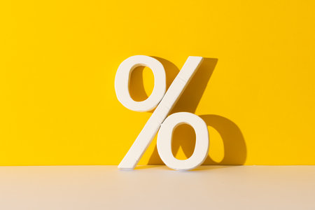 White percent sign with copy space against yellow background. Black friday, cyber monday, shopping, cyber shopping, sales, retail and shipping concept.の写真素材